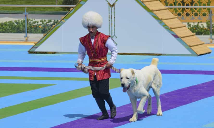 Muž v národním kroji běží v neděli 25. dubna 2021 se svým pastýřským psem Alabai během oslav psího dne v Ašchabadu v Turkmenistánu.