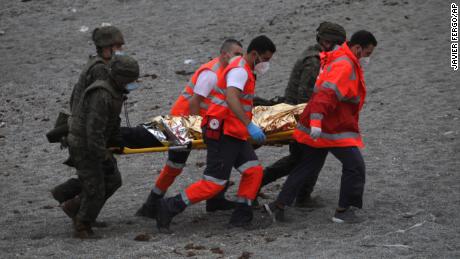 Španělská armáda a pohotovostní personál vezmou muže na nosítkách.
