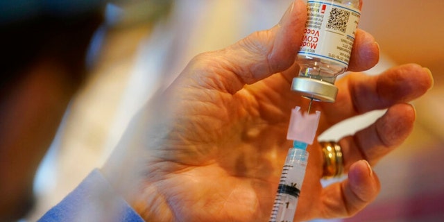 Pat Moore z ministerstva zdravotnictví Chester County v Pensylvánii naplní injekční stříkačku vakcínou Moderna COVID-19, než ji podá pohotovostním lékařům a zdravotnickým pracovníkům v Chester County Government Services Center ve West Chester, Pennsylvania (AP Photo/ Matt Slocum)