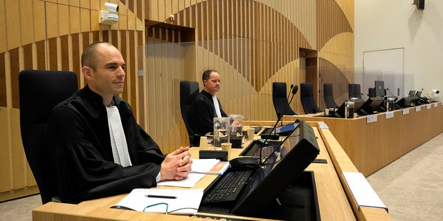 Prokurátoři Ward Ferdinandos (vlevo) a Tess Berger čekají na zahájení probíhajícího soudního a trestního řízení souvisejícího se sestřelením letu Malaysia Airlines MH17 u soudu pro nejvyšší bezpečnost na letišti Schiphol poblíž Amsterdamu v Nizozemsku v pondělí 20. prosince 2021 .