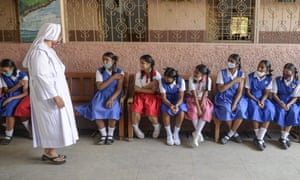 Studenti čekají v kontrolní oblasti poté, co dostali vakcínu proti Covid na dívčí střední škole v Hajdarábádu.