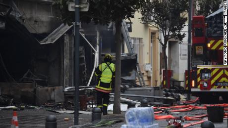 Po explozi v Saint-Laurent-de-la-Salanque 14. února 2022 stojí hasič poblíž sutin a spálených domů. 