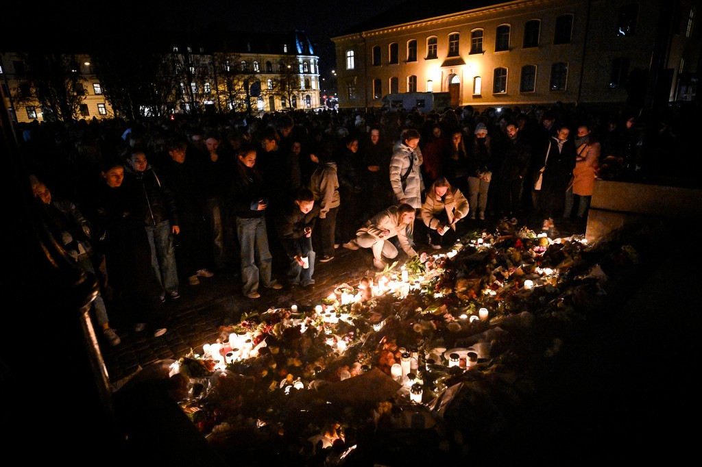 Lidé vzdávají hold dvěma učitelům, kteří byli 22. března 2022 zavražděni v latinské škole v Malmö.