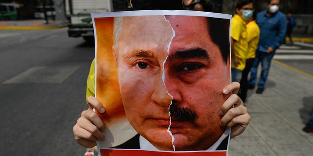 Primero Justicia drží ceduli s tváří ruského prezidenta Vladimira Putina a venezuelského prezidenta Nicolase Madura 