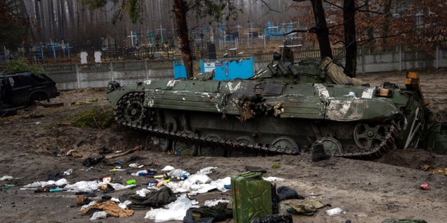 Vojenská technika zanechaná ruskými vojáky je rozházená poblíž tanku během vojenského tažení ukrajinských vojáků poté, co se Rusové v pátek 1. dubna 2022 stáhli z oblasti na předměstí ukrajinského Kyjeva. 