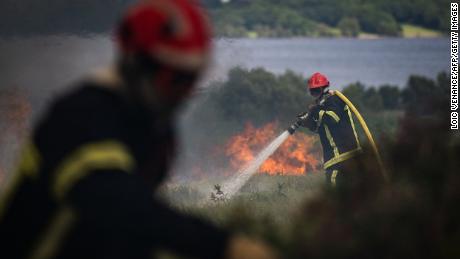 Hasiči stříkají vodu na masivní požár v Monts d'Arey v Bretani na severozápadě Francie.