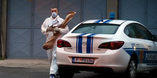 Policejní vyšetřovatel nese důkazní materiály na místě útoku v Cetinje v Černé Hoře v pátek 12. srpna 2022. Muž v pátek zahájil střelbu v ulicích města na západě Černé Hory a zabil několik lidí, než byl zastřelen.  Řekli úředníci.