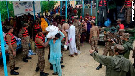 Armádní síly rozdělují potraviny a zásoby vysídleným lidem v záchranném táboře v okrese Jamshoro v jižním Pákistánu 24. srpna.